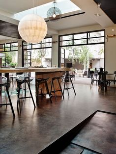 a large open kitchen and dining room with lots of windows on the side of it