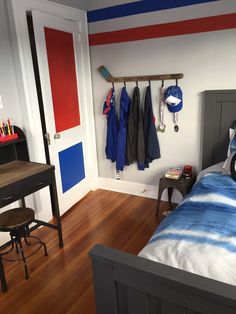 a bedroom with a bed, desk and coat rack