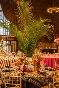 a dining room filled with lots of tables covered in table cloths and place settings