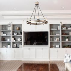 a living room filled with furniture and a flat screen tv on top of a wooden floor