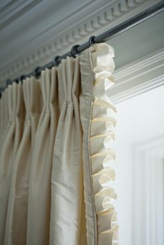 a curtain with ruffled edges hanging on a window sill