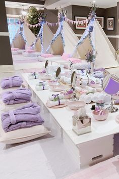 a white table topped with lots of purple towels