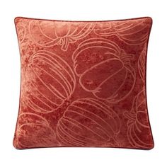 a red pillow with circles on it and an orange velvet back ground, in front of a white background