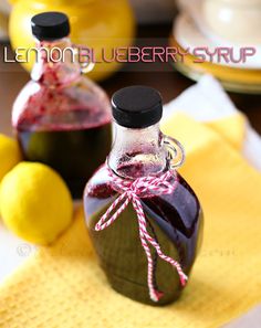 a small bottle filled with liquid sitting on top of a table next to lemons