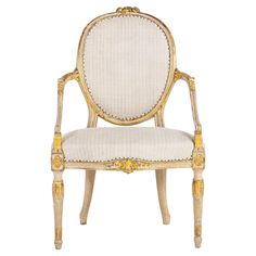 an ornately decorated chair with gold trimmings and white upholstered fabric