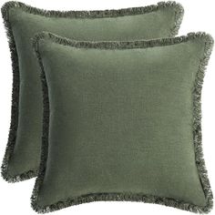 two green pillows with fringe trim