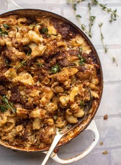 a pot filled with macaroni and cheese on top of a white tablecloth