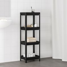 a black shelf in the corner of a bathroom