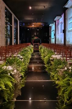 rows of chairs lined up in front of a projector screen with flowers on them