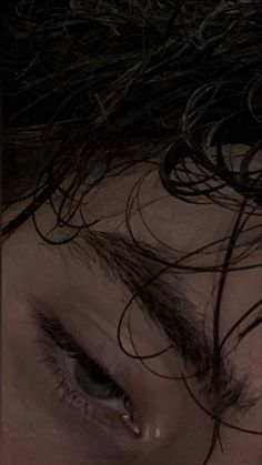 a close up of a woman's face with hair blowing in the wind