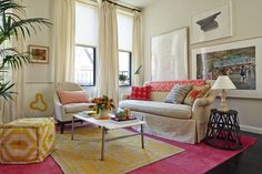 a living room filled with lots of furniture next to a large painting on the wall