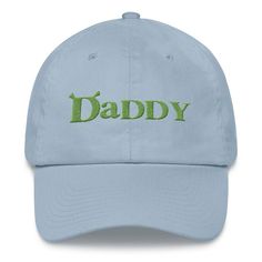 a light blue dad hat with the word daddy printed on it in green letters, against a white background