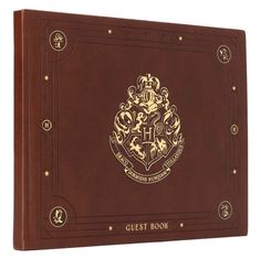 the hogwarts book is brown and has gold lettering on it, which reads guest door