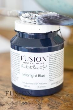 a jar of blue paint sitting on top of a wooden table