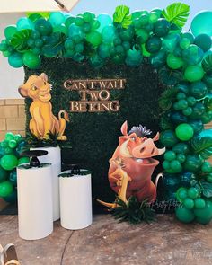 the lion king balloon arch is decorated with green balloons