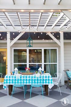 an outdoor dining area with blue and white checkered table cloth on the outside patio