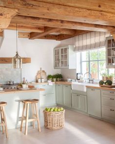 a kitchen filled with lots of counter top space and wooden beams on the ceiling above