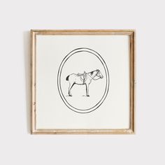 a black and white drawing of a horse in a round frame on the wall above it