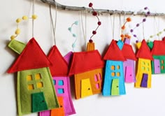 a group of colorful houses hanging from a tree branch with the words happy birthday in russian