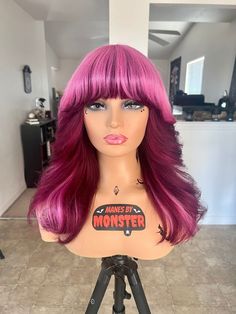 "*Made To Order Wig. Please allow 2 to 3 weeks for processing time* Custom colored pink wig with a dark magenta red halo. Shag cut with bangs and heavy face framing layers Lace free bang wig. Ready to wear glueless wig. Easy to pop on and off for a quick look. 180% Density. Cap Size - Average. 21.5\" / 22\" Circumference Combs inside cap and adjustable straps for a secure fit. Texture - Slight wave (3rd Picture is wig air dried with no product) 100% Indian Virgin Remy Human Hair Can be heat styled or colored. *Wig pictured is 16 inches* *All Manes By Monster wigs have been colored & styled with professional salon quality products* *Due to wigs being human hair, best results are achieved when hair has been heat styled or product is used. A light pomade or spray wax to tame any flyaway hairs Heavy Face Framing, Heavy Face Framing Layers, Magenta Pink Hair, Shag Cut With Bangs, Bang Wig, Shag Cut, Magenta Hair, Light Pink Hair, Hot Pink Hair