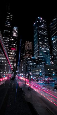 the city is lit up at night with bright lights and skyscrapers in the background