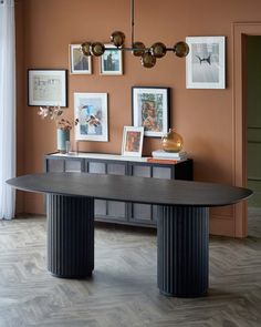 a dining room table with pictures on the wall