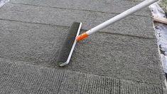 an orange and white umbrella laying on top of a gray rug next to a metal pole