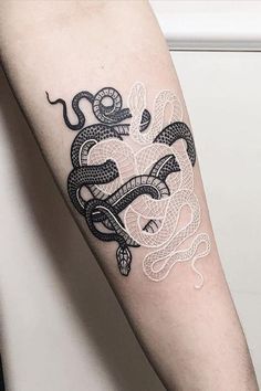 a black and white snake tattoo on the arm