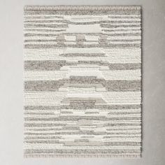 a gray and white rug hanging on the wall