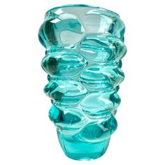 a blue glass vase sitting on top of a white table