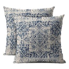 two blue and white pillows on a white background