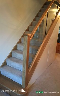 a stair case with glass balustncing and wooden handrails in a house