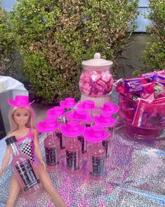 a barbie doll sitting on top of a table filled with pink candies and candy