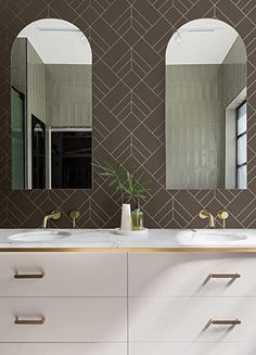 a bathroom with two sinks and mirrors on the wall next to each other in front of a green tiled wall