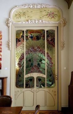 an ornate door with stained glass in the front and side panels on the back wall