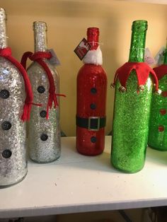 some bottles with santa hats on them sitting on a shelf next to other christmas decorations