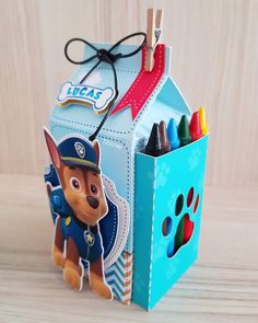 a small box with some crayons in it and a paw patrol card holder