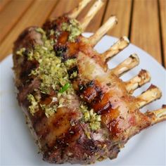 two pieces of meat on a white plate with wooden table in the backgroud