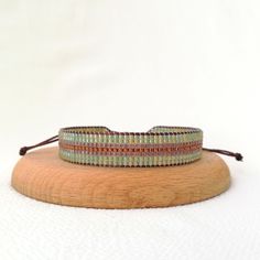 two bracelets are sitting on top of a piece of wood