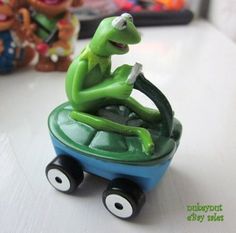 a small toy car with a chamelon riding on it