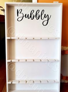 a white book shelf with the word bubbly painted on it's bottom half