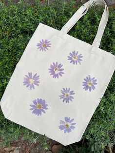 a white bag with purple flowers painted on it