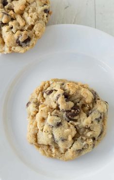 two cookies on a white plate with one cookie in the middle and one chocolate chip