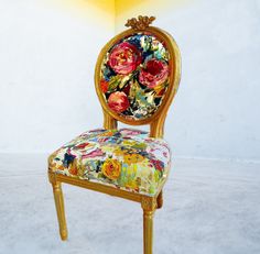 a chair with flowers painted on it sitting in front of a white wall and floor