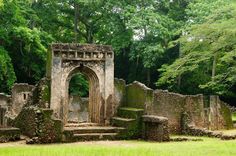 an old ruin in the middle of a forest with stairs leading up to it's entrance