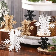 several snowflakes are sitting on a table next to pine cones and fir trees