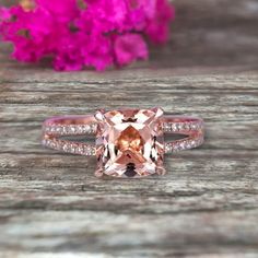 a ring with an orange morganite surrounded by pink flowers