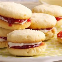 several biscuits with jam on them sitting on a plate