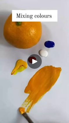 an orange being used to make mixing colours for the painting on it's surface