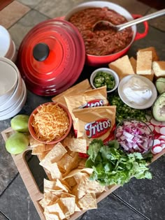 chips, salsa, and other foods are laid out on a table to be used as an appetizer